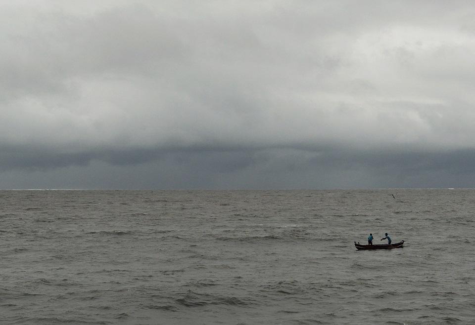 Indian fishermen collect their net as dark clouds gather over the Arabian Sea in Mumbai on July 17, 2017. Punit Paranjpe/AFP