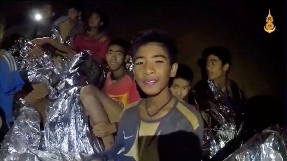 Boys from the under-16 soccer team trapped inside Tham Luang cave covered in hypothermia blankets react to the camera in Chiang Rai, Thailand, in this still image taken from a July 3, 2018 video by Thai Navy Seal. Thai Navy Seal/Handout via REUTERS