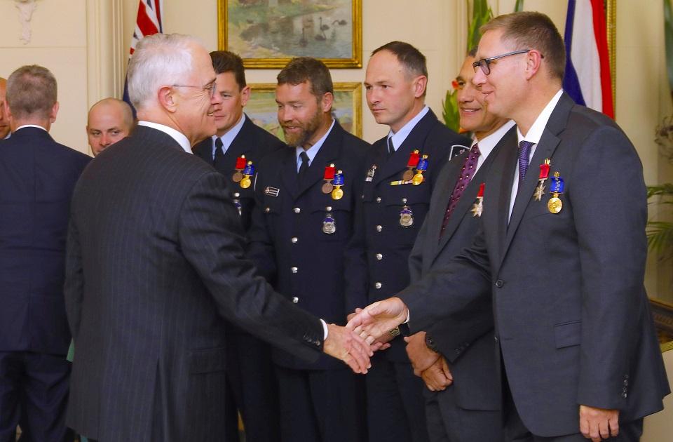 Dr. Richard Harris shakes hands with Australian Prime Minister Malcolm Turnbull as he stands with Craig Challen and members of the Australian Federal Police, all of whom were part of the Thailand cave rescue team, during an official ceremony at Government House in Canberra, Australia, July 24, 2018. AAP/Sean Davey/via REUTERS