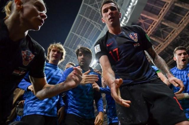 Croatia's forward Mario Mandzukic (C) offers to help AFP photographer Yuri Cortez after he fell on him with teammates while celebrating their second goal during the Russia 2018 World Cup semi-final football match between Croatia and England at the Luzhniki Stadium in Moscow on July 11, 2018. Yuri Cortez/AFP