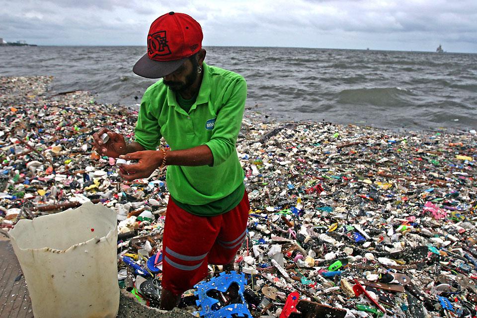 A man collects recyclable discarded plastic washed ashore in Manila Bay due to the strong wave caused by inclement weather on Monday, July 16, 2018. GMA NEWS ONLINE FILE PHOTO