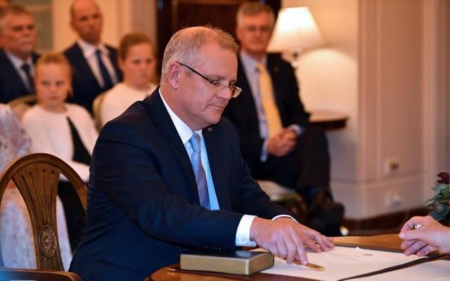 New Australian Prime Minister Scott Morrison signs documents as he takes part in an oath-taking ceremony in front of Australia's Governor General Peter Cosgrove at Government House in Canberra on August 24, 2018. Saeed Khan/AFP