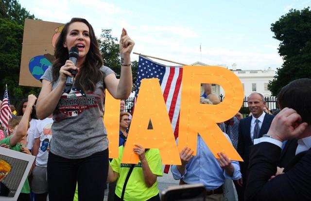 Actor Alyssa Milano makes remarks as Attorney Michael Avenatti listens, at a protest outside the White House in Washington, U.S. July 17, 2018. REUTERS/Mary F. Calvert/File photo