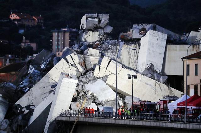 Rescuers inspect the rubble of the collapsed Morandi motorway bridge in Genoa, Italy on Tuesday, August 14, 2018. AFP/Valery Hache