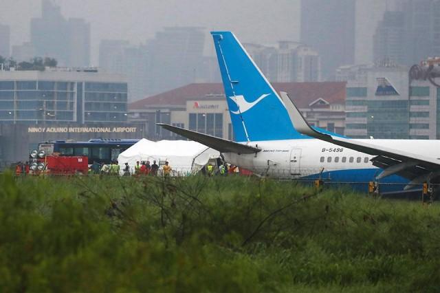 Rescuers gather near the tail of a Xiamen Airlines Boeing 737-800 after it overshot the runway at Ninoy Aquino International Airport in Parañaque City early Friday morning, August 17, 2018. Reuters/Erik De Castro