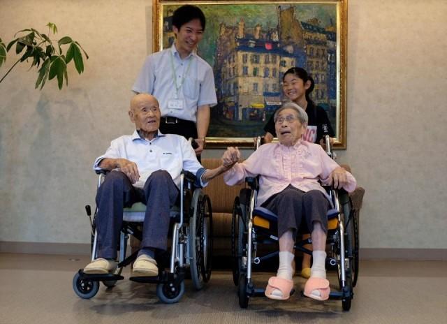 The world's oldest living married couple Masao and Miyako Matsumoto pose for a photo with their great-grandchild and their care staff at a nursing house in Takamatsu, Kagawa prefecture, Japan September 4, 2018. REUTERS/Kwiyeon Ha