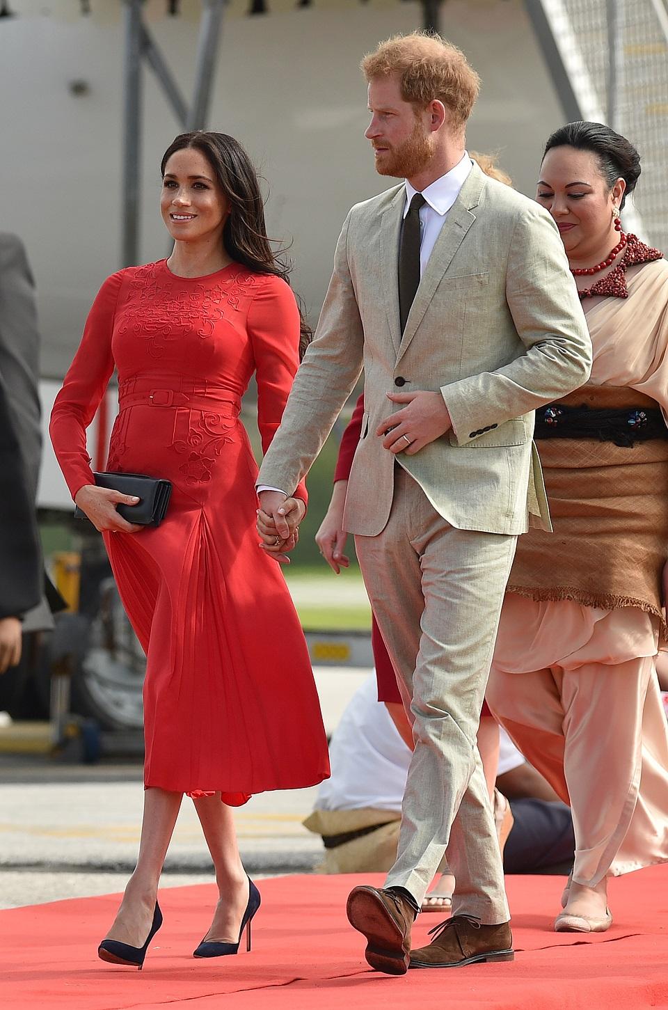 Britain's Prince Harry and Meghan, Duchess of Sussex arrive at Fua'amotu airport in Tonga on October 25, 2018. The prince and his pregnant wife left Fiji after a three-day official visit and arrived in Tonga as part of their tour of Australia and the South Pacific. Peter Parks/AFP
