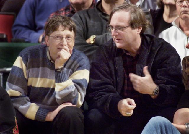 Microsoft co-founders Bill Gates (L) and Paul Allen (R) chat at courtside during the NBA game between the Seattle SuperSonics and the Portland Trailblazers at Key Arena in Seattle, March 11, 2003. REUTERS/Anthony P. Bolante/File Photo