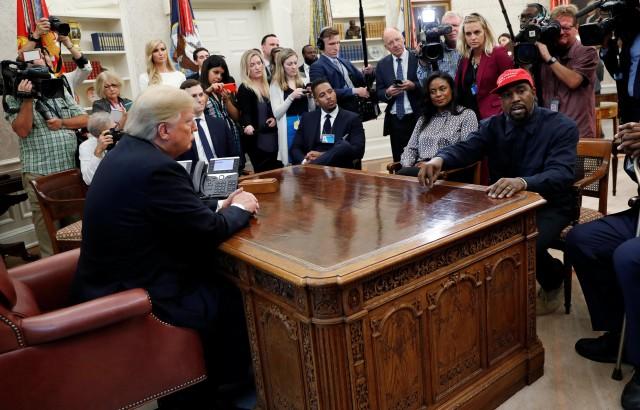 Rapper Kanye West speaks as US President Donald Trump listens during a meeting in the Oval Office of the White House in Washington, US, October 11, 2018. REUTERS/Kevin Lamarque
