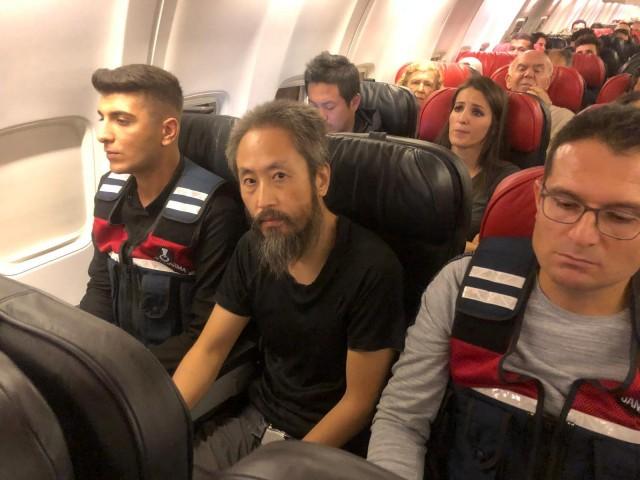 Japanese journalist Jumpei Yasuda sits between Turkish gendarmes on a Istanbul-bound flight due for departure at Hatay airport, Turkey October 24, 2018. REUTERS/Mert Ozkan