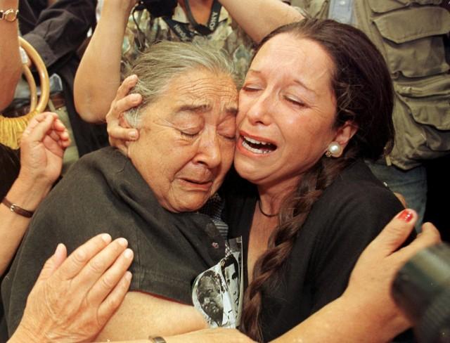 Ana Gonzalez (L) and an unidentified woman, both members of the Chilean protest group Families of the Detained and Disappeared, cry and hug each other in Santiago, Nov. 25, 1998, after hearing a ruling by Britain's House of Lords against an immunity appeal for former Chilean dictator Gen. Augusto Pinochet, allowing for his eventual extradition to Spain./File Photo