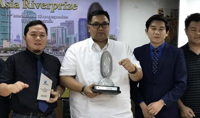 PRRC Executive Director Jose Antonio Gotio (in white) holds the 2018 Asia RiverPrize award trophy while a colleague holds the 2017 International RiverPrize runner-up award trophy. Photo: Joviland Rita