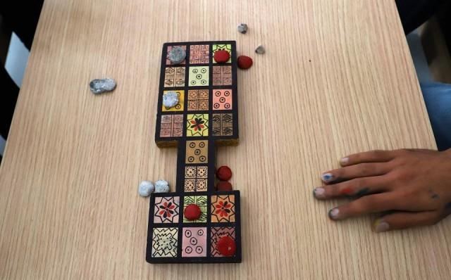 Iraqi artist Hoshmand Mofaq sits over an ancient board game, known as the Royal Game of Ur, in the northern Iraqi city of Raniey on October 22, 2018. Originating nearly 5,000 years ago in what would become Iraq, the Royal Game of Ur mysteriously died outâuntil Muwafaq resurrected it by making his own decorated wooden board. Shwan Mohammed/AFP