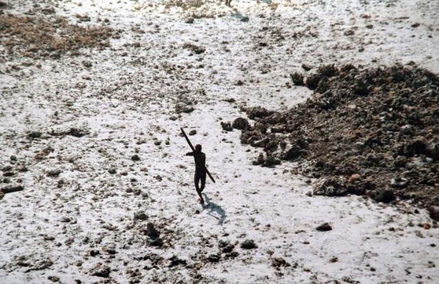 In this handout photo provided by the Indian Coast Guard and Survival International and taken on December 28, 2004, a man with the Sentinelese tribe aims his bow and arrow at an Indian Coast Guard helicopter as it flies over North Sentinel Island in the Andaman Islands in the wake of the 2004 Indian Ocean tsunami. Handout/Survival International/Indian Coast Guard/AFP