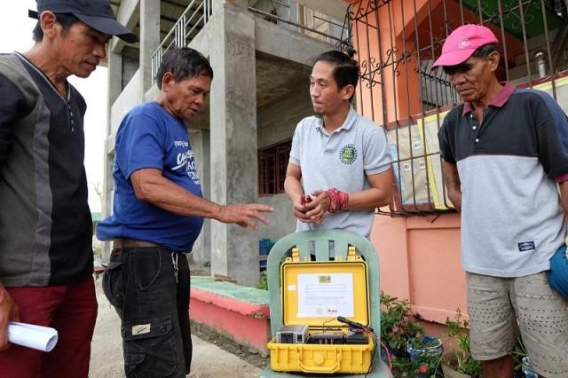 Glinly Alvero, a RE-Serve Humanitarian Corps volunteer and Institute for Climate and Sustainable Cities technical officer, demonstrates the use of the solar-powered TekPak to locals of Brgy. Afusing Batu in Alcala, Cagayan. The locals are not familiar wit