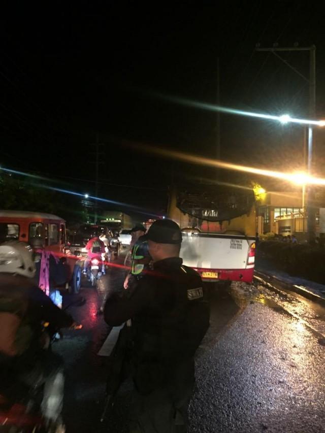 Policemen from the City of Naga Police Station redirect traffic after a bus, which was on its way to Cebu City from Badian town, caught fire. PHOTO BY CITY OF NAGA POLICE STATION