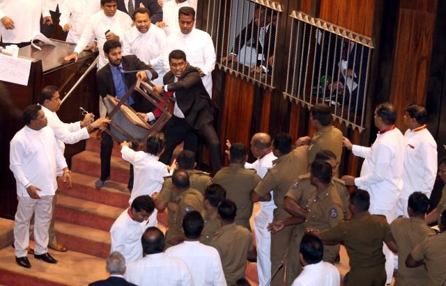 Parliament member Johnston Fernando, who supports newly appointed Prime Minister Mahinda Rajapaksa, throws a chair at police who are there to protect parliament speaker Karu Jayasuriya (not in picture) during a parliament session in Colombo, Sri Lanka November 16, 2018. REUTERS
