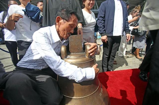 Nemencio Duran, who claims his grandfather was the last man who rang the Balangiga bells, kisses them upon their return to the Philippines on Tuesday, December 11, 2018, after 117 years in a US military camp. The three church bells were taken by the US Army from the San Lorenzo de Martir church in Balangiga, Eastern Samar, as war trophies during the Philippine-American War after reprisals following the Balangiga massacre in 1901. Danny Pata 