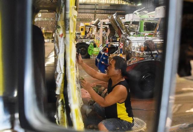 This photo taken on October 27, 2018 shows Vic Capuno, 52-year-old jeepney artist, painting a jeepney in a workshop in San Pablo, Laguna. Ted Aljibe/AFP