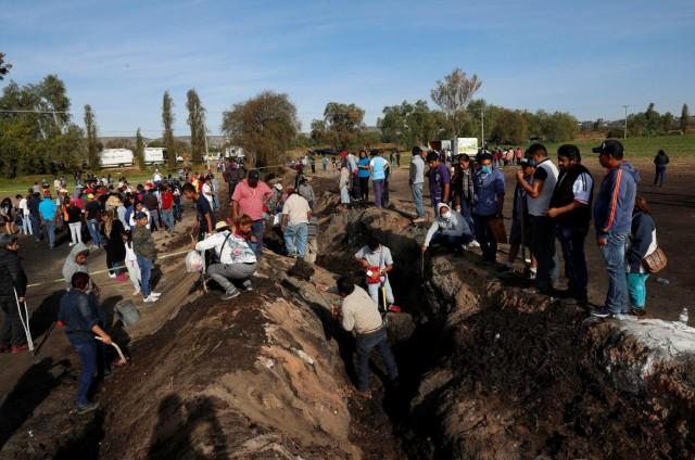 Residents search for human remains and items that could help to identify their missing relatives and friends at the site where a pipeline ruptured by oil thieves exploded, in the municipality of Tlahuelilpan, state of Hidalgo, Mexico January 20, 2019. REUTERS/Henry Romero