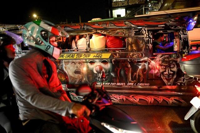 This picture taken on January 14, 2019 shows custom artwork on the side of a jeepney during rush hour in Manila. Hand-painted custom decor on these vehicles adorned with images of everything from Batman to babies, as well as disco lights and chrome wheels, have for decades provided cheap transport for millions of Filipinos. AFP/Noel Celis 