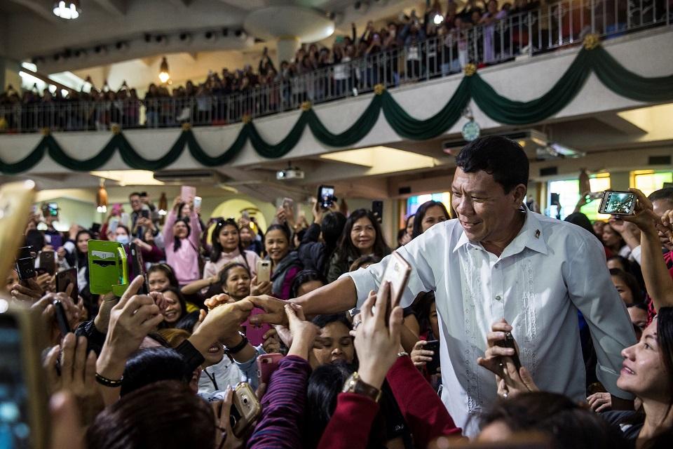  A Rodrigo Duterte impersonator who goes by the name Cresencio Extreme shakes hands as he attends a church service in the Central district of Hong Kong on February 3, 2019. Isaac Lawrence/AFP