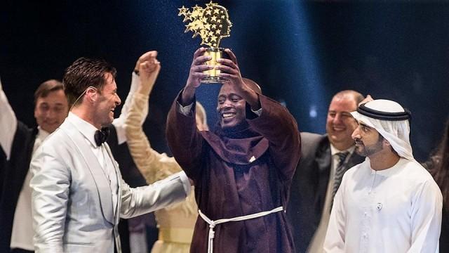 Kenyan teacher Peter Tabichi holds up the Global Teacher Prize trophy after winning the US$1 million award at an official ceremony in Dubai presented by Hugh Jackman (L) and attended by the Dubai Crown Prince Hamdan bin Mohammed Al-Maktoum (R). Global Education and Skills Forum/AFP