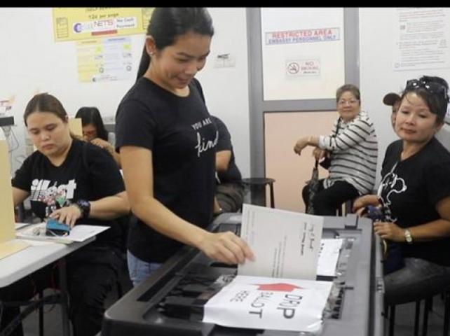 An OFW casts her ballot in Singapore during the first day of overseas absentee voting at the Philippine Embassy in Singapore. 