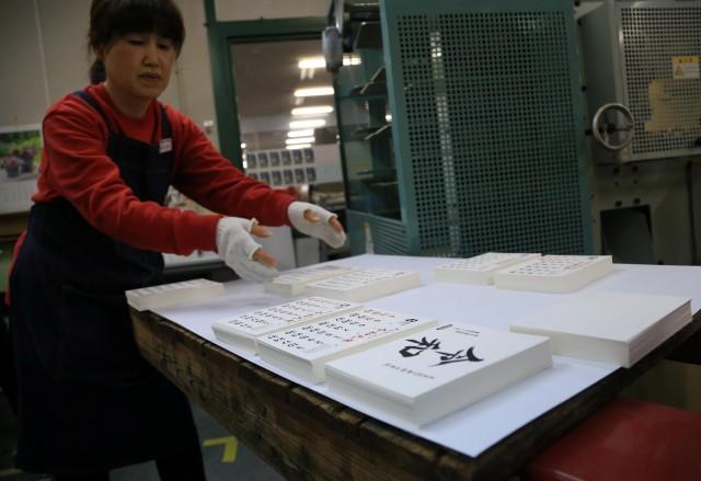 An employee of Japan's calendar maker Todan Co. Ltd. produces calendars with the new era name 'Reiwa' after the government's announcement in Yoshiwara, Ibaraki Prefecture, Japan, April 1, 2019. REUTERS/Masashi Kato