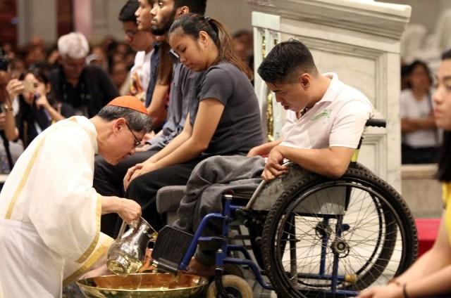 Cardinal Luis Tagle washes the feet of Carlito Sapunto during the washing of the feet at the Manila Cathedral in Intramuros Manila on Maundy Thursday, April 18, 2019. A church volunteer at the St. Dominic Savio Parish in Mandaluyong, Sapunto is also an awarded player of boccia, a ball sport played by people with disabilities that affect motor skills. DANNY PATA