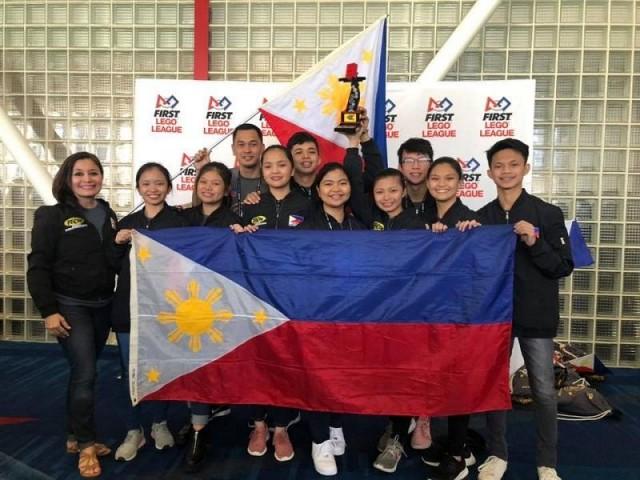 The Philippine Robotics National Team (DYCI Blue Ocean’s 10 from Dr. Yanga’s College, Inc.) with Ms. Mylene Abiva of FELTA Multi-Media (leftmost) at the FIRST Lego League World Championship in Houston, Texas, USA. Photo courtesy of FELTA.