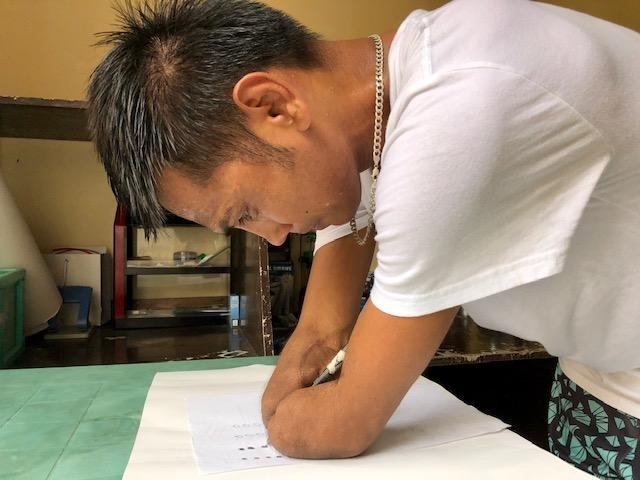 Ronnie De Villa prepared well before he cast his vote on Monday, as he practiced shading sample ballots. PHOTO BY JOHN CONSULTA