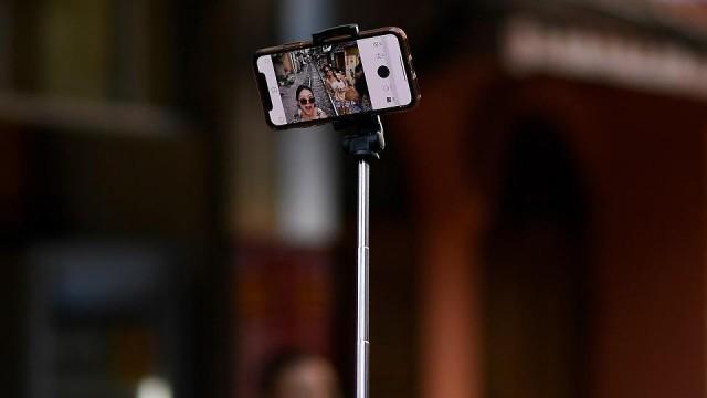 Women pose for a selfie on the railway track in Hanoi's popular train street on June 9, 2019. Manan Vatsyayana/AFP