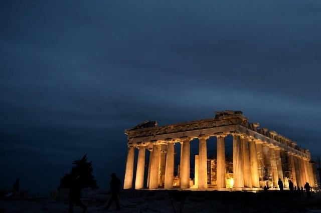 People stand in front of the ancient Temple of Parthenon atop the Acropolis hill on October 4, 2013. Aris Messinis/AFP Athens, Greece