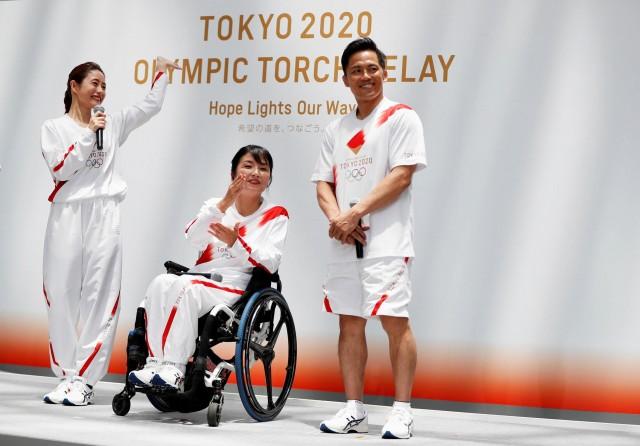 Tokyo 2020 Torch Relay Official Ambassadors, actress Satomi Ishihara, paralympian Aki Taguchi and judoist Tadahiro Nomura unveil the Olympic torchbeares' uniform during a Torch Relay event to mark the 300 day milestone of the starting date of the torch relay, in Tokyo, Japan June 1, 2019. REUTERS/Issei Kato