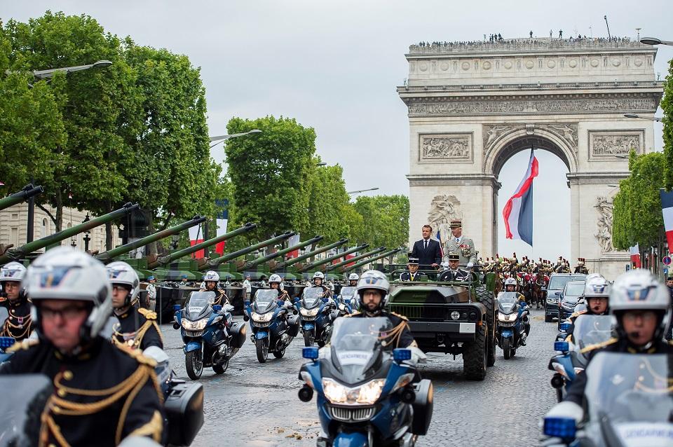 France's President Emmanuel Macron stands in an Acmat VLRA vehicle next to French Armies Chief Staff General Francois Lecointre as they review troops before the start of the Bastille Day military parade down the Champs-Elysees avenue in Paris on July 14, 2019. Eliot Blondet/Pool/AFP