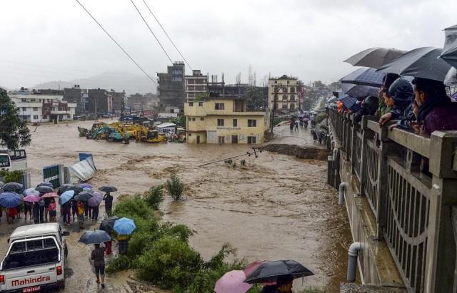 Residents look at floodwaters after the Balkhu River overflowed following monsoon rains at the Kalanki area of Kathmandu, Nepal on July 12, 2019.