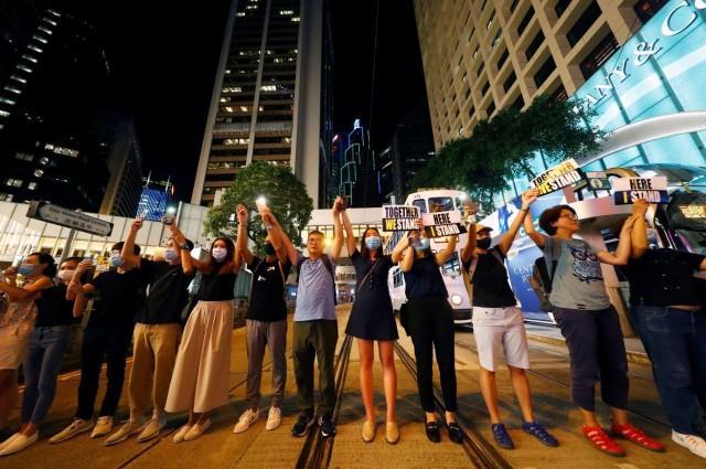 Anti-extradition protesters hold hands across a street in Hong Kong's Central district, China, August 23, 2019. REUTERS/Kai Pfaffenbach