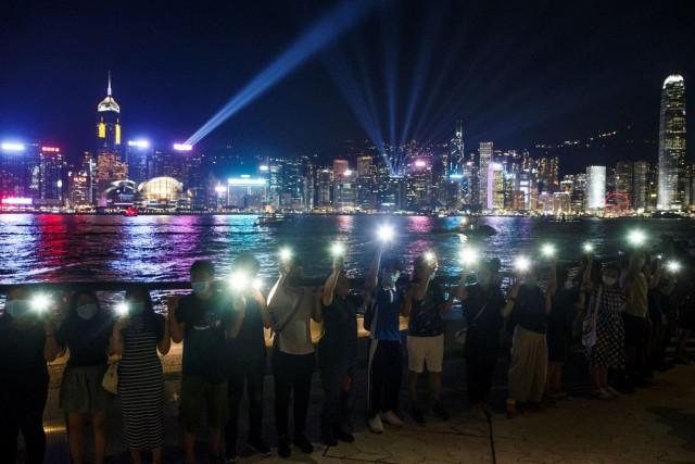 Protesters hold hands to form a human chain during a rally to call for political reforms at the Avenue of Stars in Hong Kong, China, August 23, 2019. REUTERS/Thomas Peter