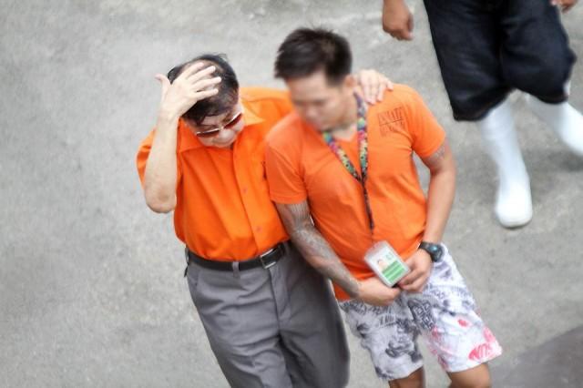 Former Calauan, Laguna mayor Antonio Sanchez (left), convicted for raping and murdering a college student and her friend in the 90s, covers his balding top as he walks with an inmate at the maximum security compound of the New Bilibid Prison in Muntinlupa City on Thursday, August 22, 2019. Danny Pata 