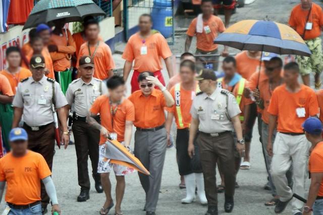 Former Calauan, Laguna mayor Antonio Sanchez (center, in sunglasses), convicted for raping and murdering a college student in 1993, is escorted by fellow inmates as he walks along with a Bureau of Corrections official at the maximum security compound of the New Bilibid Prison in Muntinlupa City on Thursday, August 22, 2019. Reports of his possible release have sparked outrage. Danny Pata 