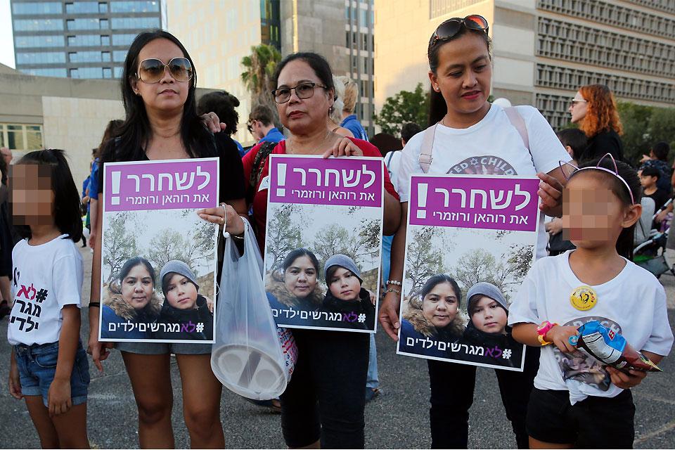 Filipino children and their mothers carry a banner which reads in Hebrew 'release Filipina mother and her son' during a protest against deportation in Tel Aviv on Tuesday, August 6, 2019. Hundreds of people demonstrated in Israel against the deportation of Filipino children born in Israel from migrant workers but without any legal status. AFP/Gil Cohen-Magen 