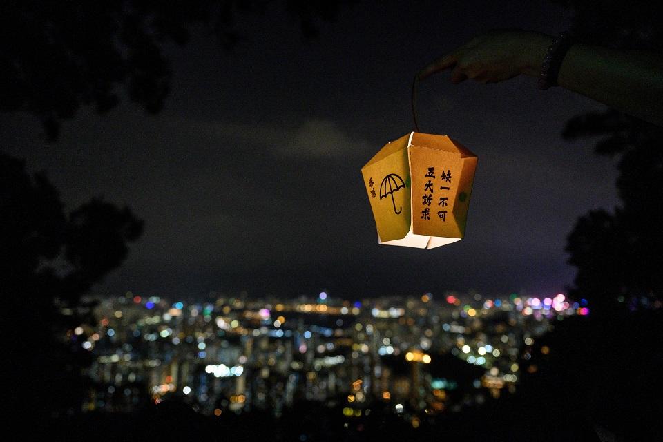 A woman holds a paper lantern as she takes part in forming a human chain with other pro-democracy activists on Lion Rock in Hong Kong on September 13, 2019. Anthony Wallace/AFP