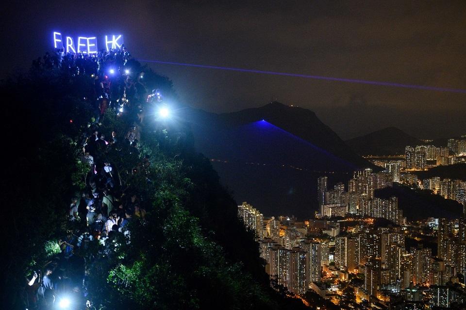 Pro-democracy activists hold up LED-lit letters reading "Free HK" as others shine torch lights, lights from their phones and lasers while forming a human chain on Lion Rock in Hong Kong on September 13, 2019. Anthony Wallace/AFP