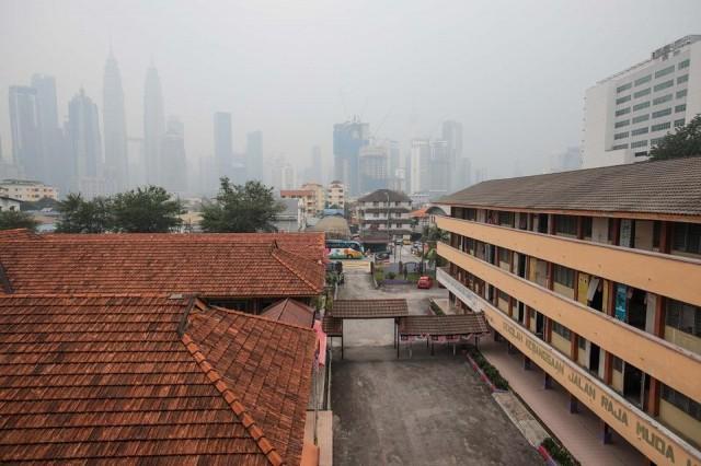 An empty school with landmark Petronas Twin Towers (L) in the background are seen blanketed by haze in Kuala Lumpur on September 18, 2019. The toxic haze came from Indonesian forest fires. Sadiq Asyraf/AFP