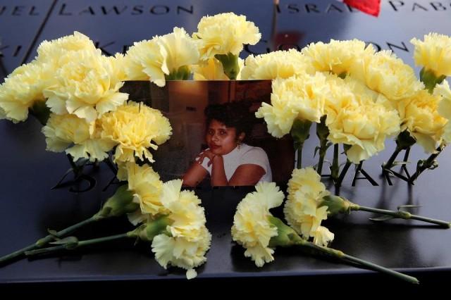 A photograph of a 911 victim and flowers are seen left at the north reflecting pool during ceremonies commemorating the 18th anniversary of the September 11, 2001 attacks at the 911 Memorial in lower Manhattan in New York, on September 11, 2019. REUTERS/Brendan Mcdermid