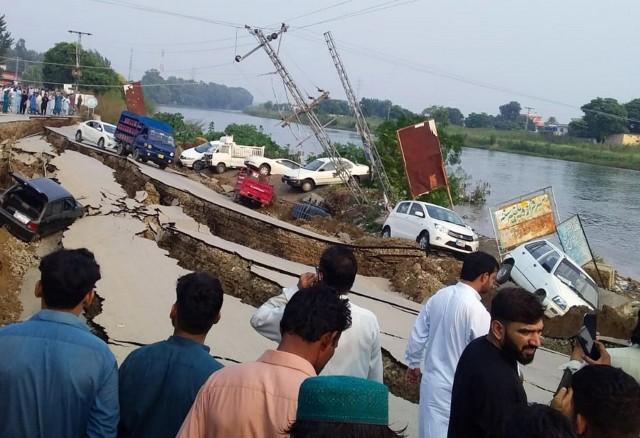 People gather near a damaged road after an earthquake of magnitude 5.8 in Mirpur, Pakistan September 24, 2019. REUTERS