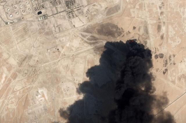 A satellite image shows thick black smoke billowing from an apparent drone strike on an Aramco oil facility in Abqaiq, Saudi Arabia on Saturday, September 14, 2019. Oil prices surged to six-month highs on Monday while Wall Street futures turned lower and safe haven bets returned after the attacks on Saudi Arabia's crude facilities knocked out more than 5% of global oil supply. Planet Labs Inc/via Reuters 