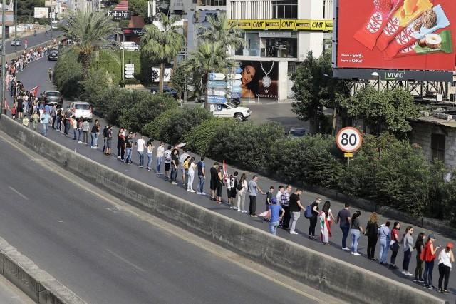 Lebanese protesters hold hands to form a human chain along the coast from north to south as a symbol of unity during ongoing anti-government demonstrations on Jounieh highway north of Lebanon's capital Beirut on October 27, 2019. Joseph Eid/AFP