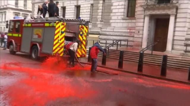 Screen grab from video showing: climate change activists spraying red paint at facade of british finance ministry from fire engine. Reuters 